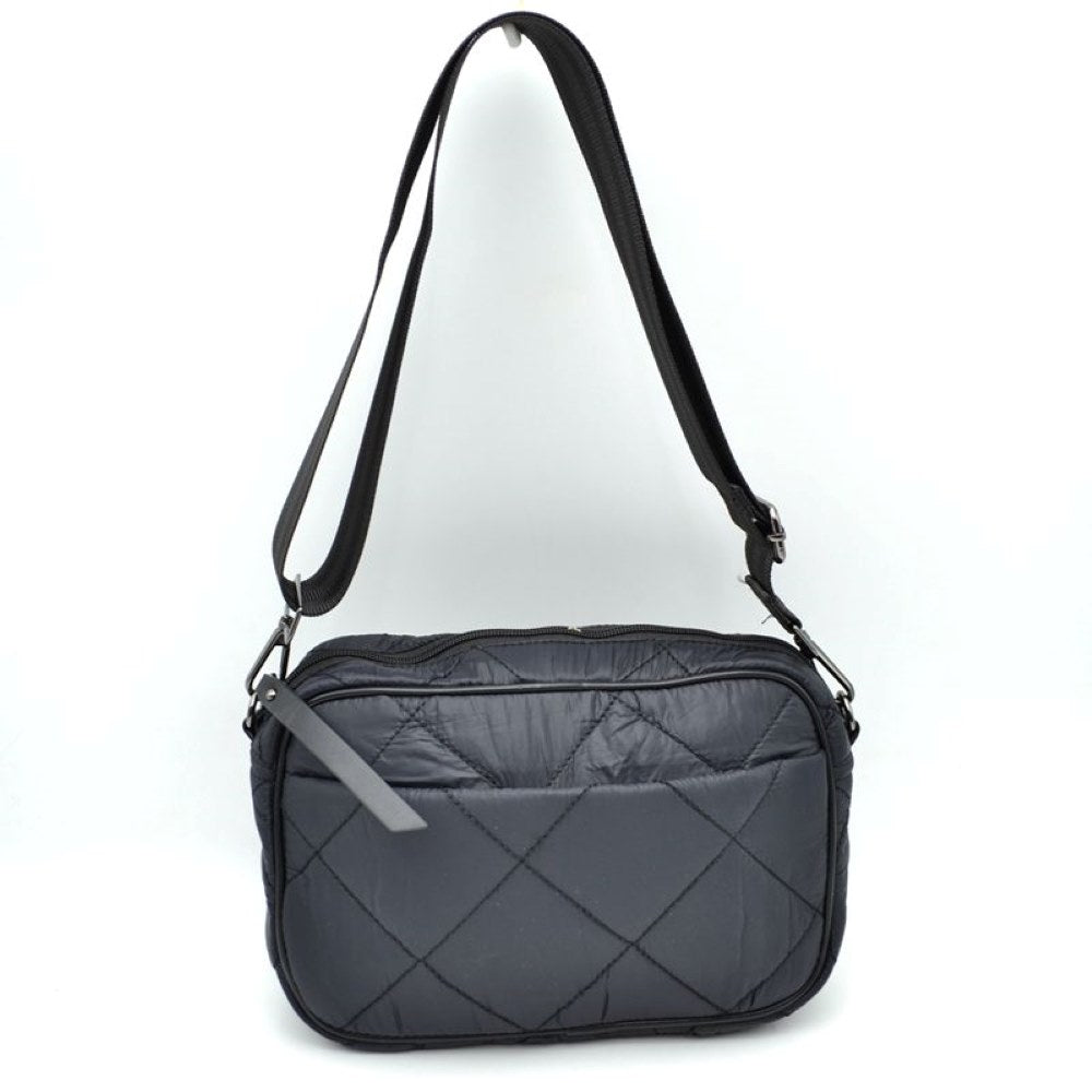Black This functional crossbody bag features a soft, lightweight puffer exterior with a classic quilted diamond pattern in a sleek dark grey tone, making it a practical choice for organized daily use. The front panel is detailed with a subtle open slip pocket accented by a long, flat fabric pull on the corner. Equipped with a secure top zipper closure to keep your main compartment essentials safe, the bag is finished with gunmetal-tone hardware and a long, adjustable webbing shoulder strap for a comfortable