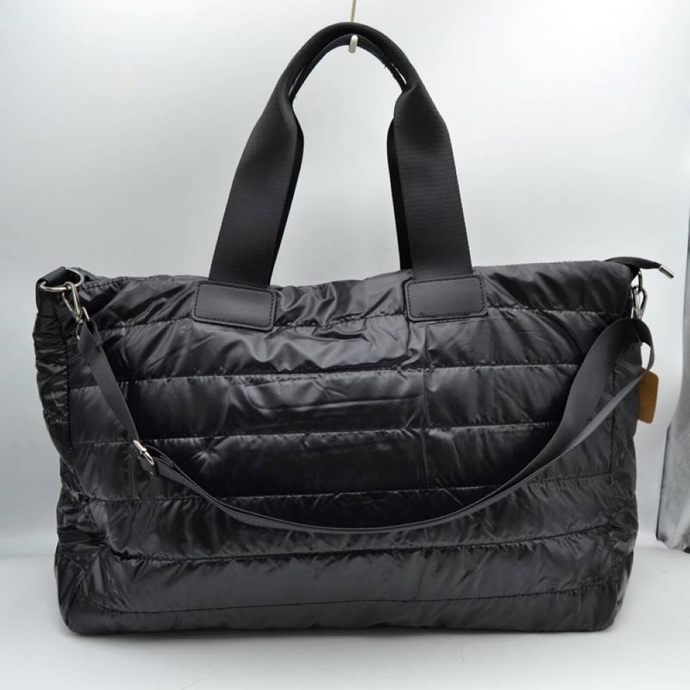 Black Upgrade your travel gear with this exceptionally spacious, lightweight weekender duffel bag, perfect for overnight trips, gym sessions, or casual weekend getaways. Featuring a stylish horizontally quilted puffer design, this bag combines a cozy, modern aesthetic with highly practical function. It is designed with wide, durable webbed top handles for a comfortable grip, alongside a matching adjustable and detachable shoulder strap secured by polished metallic clasps for easy hands-free carrying.