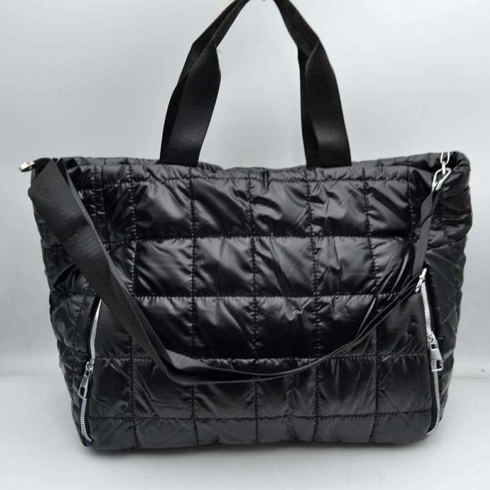 Black Simplify your travel routine with this highly functional, lightweight grid-quilted puffer duffel bag, perfectly proportioned for overnight stays, weekend road trips, or gym days. Featuring a contemporary square quilted design, this soft-structured bag brings an athletic yet polished aesthetic to your transit style. The exterior features two prominent vertical zippered pockets on the lower front corners, keeping your passport, keys, or phone easily accessible while on the move.