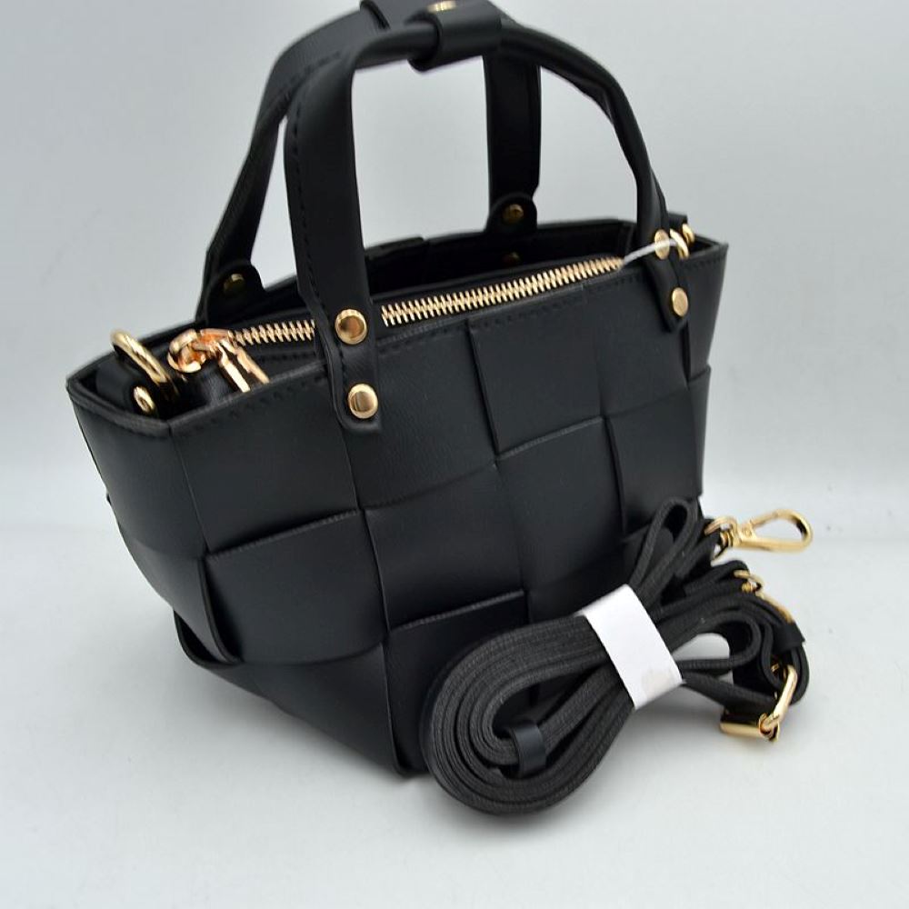 Black Infuse a touch of modern luxury into your accessory collection with this striking square mini tote bag. Defined by an oversized, wide-interlocking basket weave design, this bag delivers a clean, architectural aesthetic with plenty of dimensional texture. It features sturdy dual top handles secured by polished metallic rivets, alongside a full top-zipper closure to keep your belongings tucked safely away. For seamless, on-the-go versatility