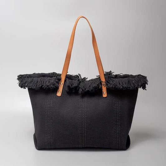 bLACK This spacious tote bag features a finely textured main body adorned with an eye-catching, voluminous fringe trim entirely wrapping around the upper opening. Designed for versatile everyday use, the bag is equipped with dual flat shoulder straps anchored securely to the front and back panels by metallic rivets.