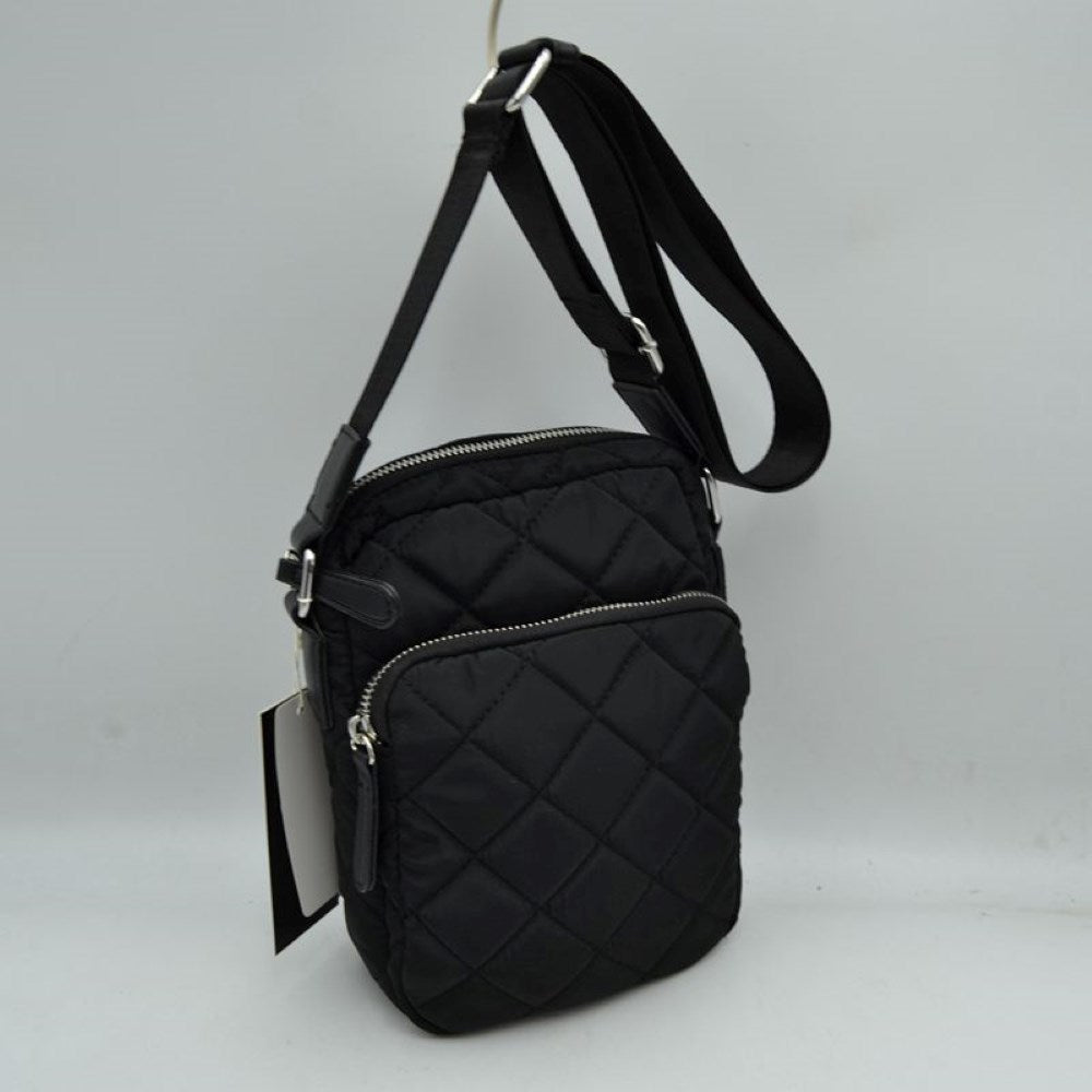 Black This structural trapeze handbag showcases a clean exterior finish and distinct flared side panels, offering an elegant aesthetic for everyday use. It features unique rounded top handles shaped like segmented bamboo rings, which are attached securely via wide decorative tabs and metallic hardware on the front and back. A top zipper closure with an extended pull tab opens up to a secure main storage compartment, keeping all your essential items safe and neatly organized.
