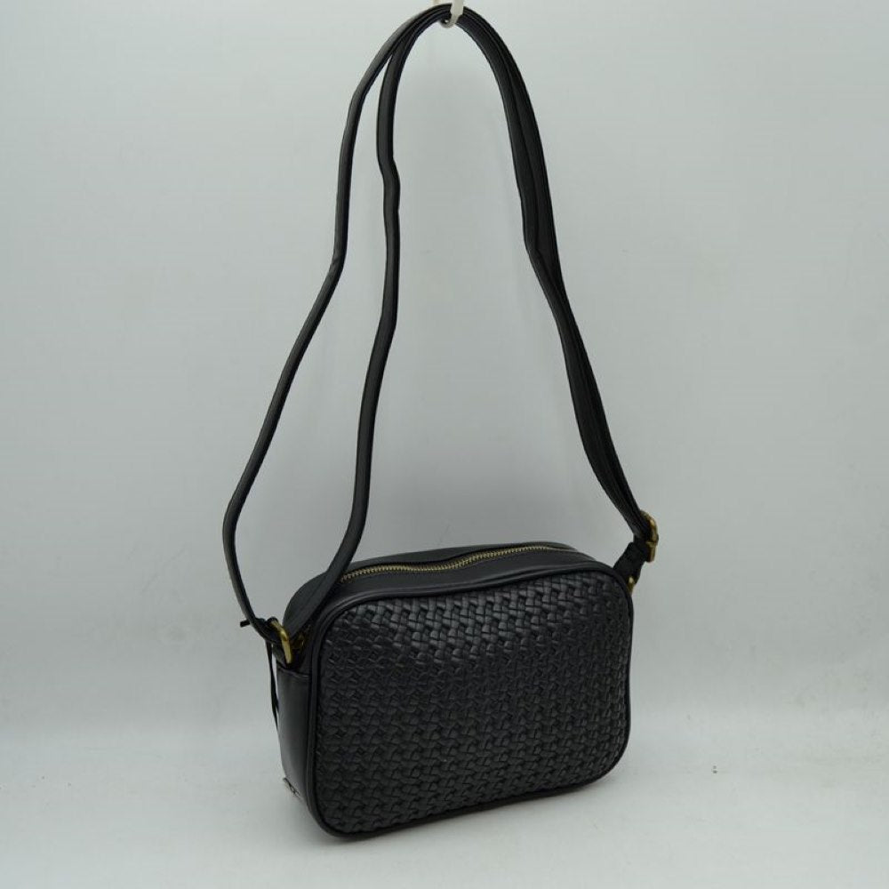 Black This stylish crossbody bag combines a smooth, classic black exterior with an intricate woven front panel, offering a textured and sophisticated look for everyday use. Its compact, rectangular camera-bag silhouette features a secure top zipper closure with gold-tone hardware to keep your daily essentials safe and organized. Completed with a long, matching adjustable shoulder strap, this versatile bag can be styled comfortably over the shoulder or across the body for hands-free convenience.