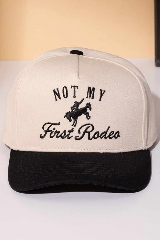 Black Classic trucker cap with bold "NOT MY FIRST RODEO" embroidery across the front. Features a two-tone design that blends style with attitude. Crafted from 100% cotton for breathability and comfort. Snapback closure adjusts to fit most head sizes. Perfect for casual wear, outdoor adventures, or making a statement wherever you go.
