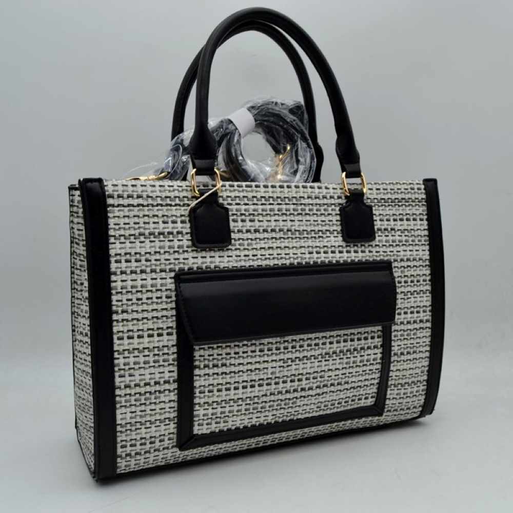 Black Bring a polished, professional edge to your daily commute with this beautifully structured rectangular tote bag. Showcasing a refined, multi-tonal woven tweed patterned exterior, this handbag is sharply framed by clean, solid-colored vertical trim and a matching protective base that effortlessly retains its crisp silhouette. The front features a prominent, smooth-textured slip pocket with a protective overhanging flap, offering convenient, easy-access storage for smaller items like keys or commuter pa