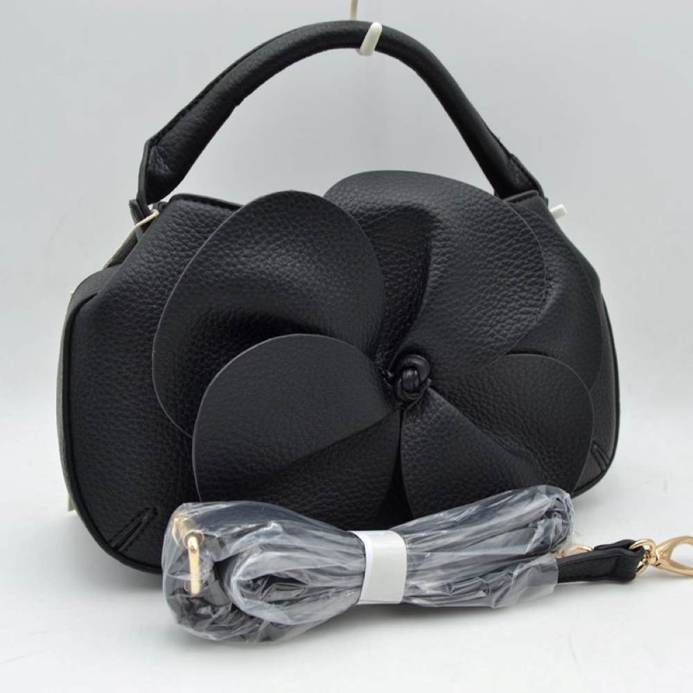 Black Make a striking fashion statement with this avant-garde pebble-grain handbag. Defined by its dramatic, oversized three-dimensional leather flower overlay on the front panel, this unique bag effortlessly bridges the gap between modern sculptural art and functional everyday luxury.