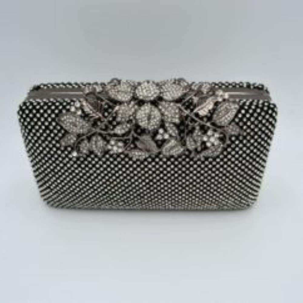 Black Designed with a rigid rectangular silhouette, this sophisticated box clutch features a meticulously textured exterior composed of small, shimmering circular studs arranged in a uniform pattern. A detailed overlay consisting of metallic leaves and floral accents spans across the top closure, creating an elegant focal point while securing the main storage compartment. A matching link chain strap attaches seamlessly to the top edges