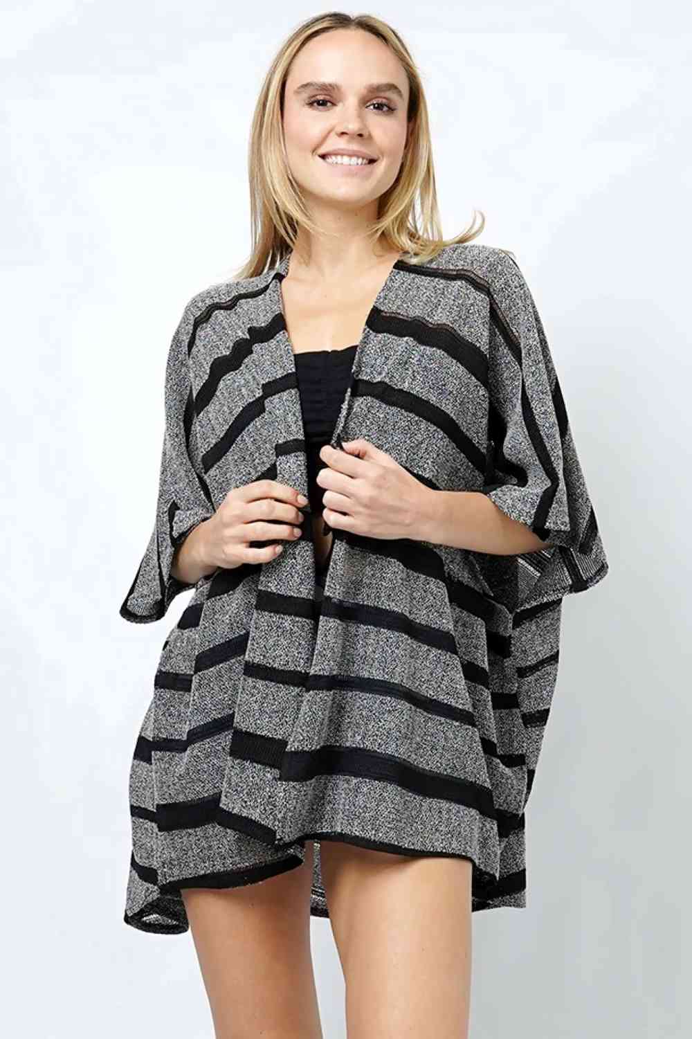 Black Effortless layering meets timeless style with this Stripe Relaxed Fit Knit Kimono. Crafted from 100% polyester, this lightweight piece drapes beautifully over any outfit, offering comfort without compromise. The relaxed fit ensures easy movement, while the classic stripe pattern adds visual interest to casual and dressed-up looks alike. At 31" in length, it's the perfect length for versatile styling. Throw it on over a tee, dress, or sweater for an instantly polished appearance.
