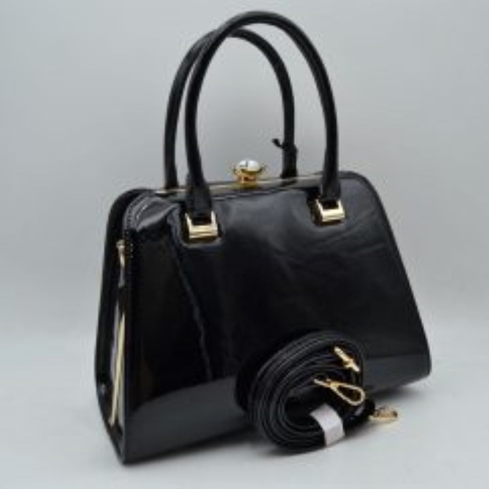 Black This sophisticated frame handbag features a high-shine patent finish and a structured trapezoidal silhouette, making it an elegant choice for evening or formal wear. Designed with a classic frame top closure, it is secured by a distinctive pearl-accented gold-tone twist lock. Dual rolled top handles attached via polished metallic hardware allow for stylish handheld carrying, while an included detachable shoulder strap with gold-tone clasps offers versatile hands-free shoulder options.