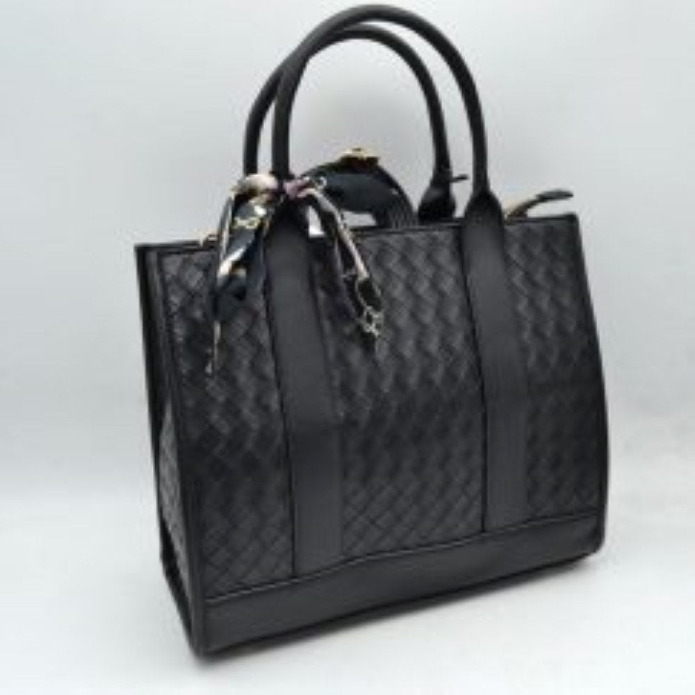 Black This structural tote bag features an intricate woven textured pattern across its panels, delivering a sophisticated look suitable for everyday use. It is designed with dual rounded top handles extending down the front and back as solid vertical bands, alongside a secondary adjustable strap visible behind for alternative carrying options. The spacious main storage compartment secures with a top zipper closure