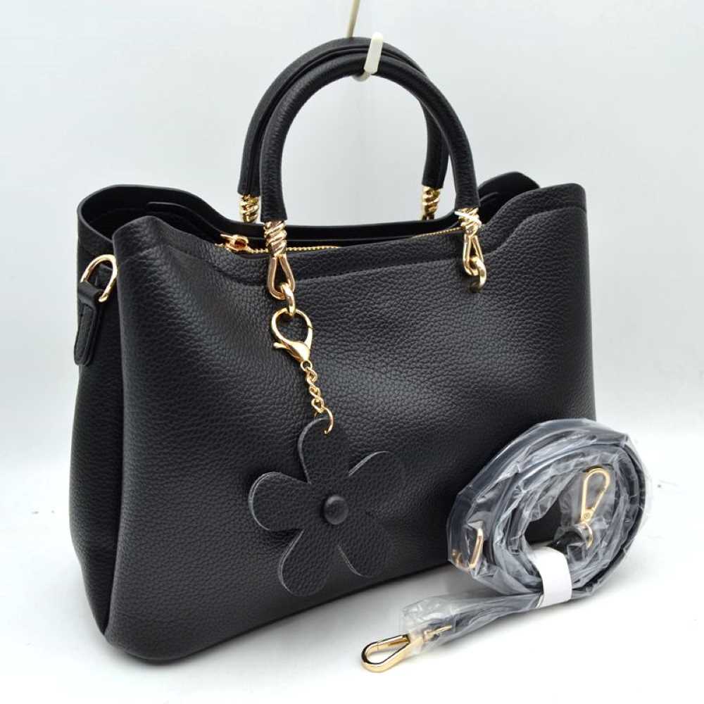 Black Add a refined touch to your everyday accessories with this stylish satchel bag featuring structured top handles, a spacious interior, and a detachable shoulder strap for versatile carrying options. Designed to balance fashion and functionality, it offers ample room for daily essentials while maintaining a sleek and sophisticated silhouette. Decorative hardware accents and a charming floral pendant enhance its elegant appearance, making it suitable for work, shopping, travel, or casual outings.