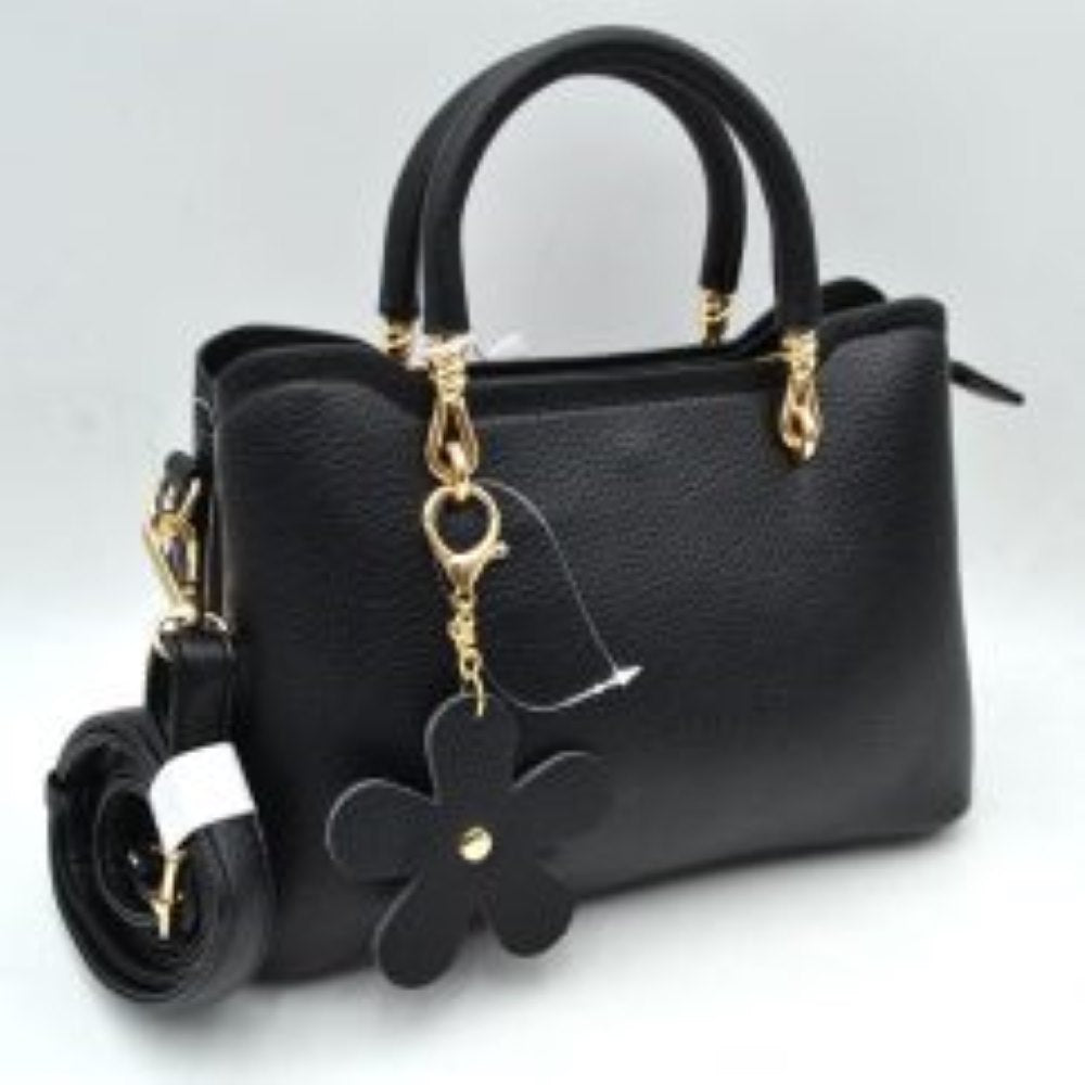 Black This elegant satchel handbag features a structured silhouette with a pebbled exterior texture, making it a sophisticated option for everyday use. It is equipped with dual rounded top handles anchored by polished metallic loops, alongside a detachable, adjustable shoulder strap connected to the side by a swivel clasp for versatile carrying styles. The main storage compartments include an open side section and a secured top zipper closure to keep essentials organized