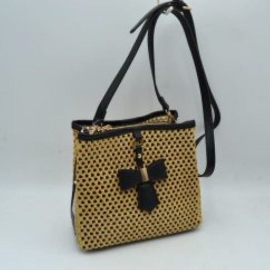 Black This structural crossbody bag features an intricate, open-weave mesh pattern across its body, offering an eye-catching and distinctive look for everyday use. A contrasting central vertical tab on the front panel is highlighted by a structured decorative bow accent anchored with metallic hardware. Built for easy organization, the bag contains multiple secure storage compartments including dual top zippers, while a long, adjustable slim shoulder strap loops smoothly over the top to provide comfortable