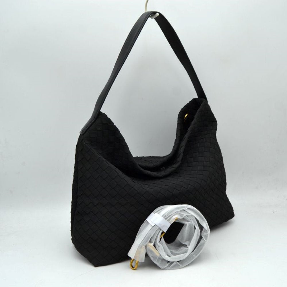 Black This slouchy hobo bag showcases a textured woven pattern across its exterior, offering a refined look that is perfect for everyday use. The spacious main compartment provides ample storage for daily essentials, featuring a relaxed silhouette with a flat top shoulder strap for comfortable carrying. A separate, detachable secondary strap with metallic clasps is included, allowing for versatile styling options to suit your needs.