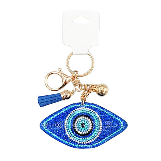 Blue Bling Evil Eye Tassel Bag Charm is a stylish accessory that adds a touch of glam to any bag. With its sparkling design and protective evil eye symbol, this charm is not only fashionable but also serves as a good luck charm. Perfect for adding a unique touch to your bag collection.