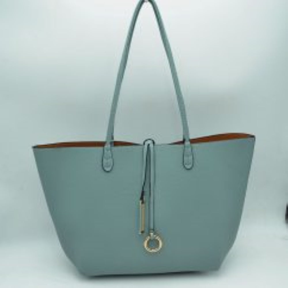 Blue-Brown This classic tote bag features a smooth exterior finish with a timeless trapeze silhouette, offering an elegant look for everyday use. Designed with an open top for quick access, the spacious main compartment provides ample storage space for daily essentials. Dual slim shoulder handles are securely stitched to the upper panels, while a decorative central drawstring tie accents the front, complete with a metallic ring and matching tab accent for a polished touch.