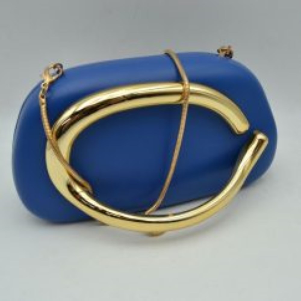 Blue This structured, hard shell clutch bag functions as an elegant accessory for everyday use or special occasions, featuring a smooth matte surface. A large, prominent metallic ring handle anchors the front design, offering a secure hand-held grip. For alternative carrying styles, the bag is equipped with a detachable metallic snake chain strap that secures to the top corners with lobster claw clasps, providing functional storage in a compact, rigid silhouette.