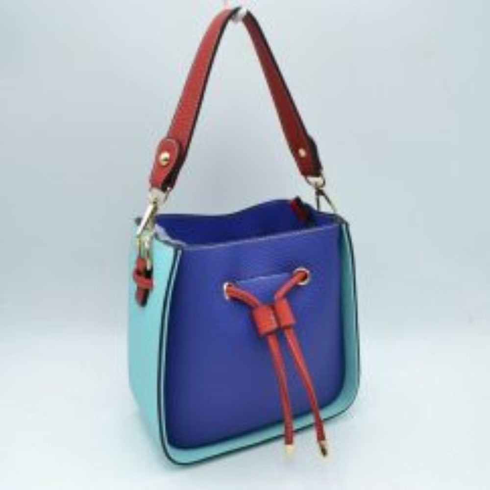 Blue This stylish bucket bag features a distinctive color-blocked design crafted with a pebbled exterior texture, making it a versatile accessory for everyday use. The front panel includes a classic cinch drawstring closure detailed with contrasting trim and polished metallic aglets that open to a secure main storage compartment. Built for flexibility, it is equipped with a structured shoulder handle, an adjustable long shoulder strap