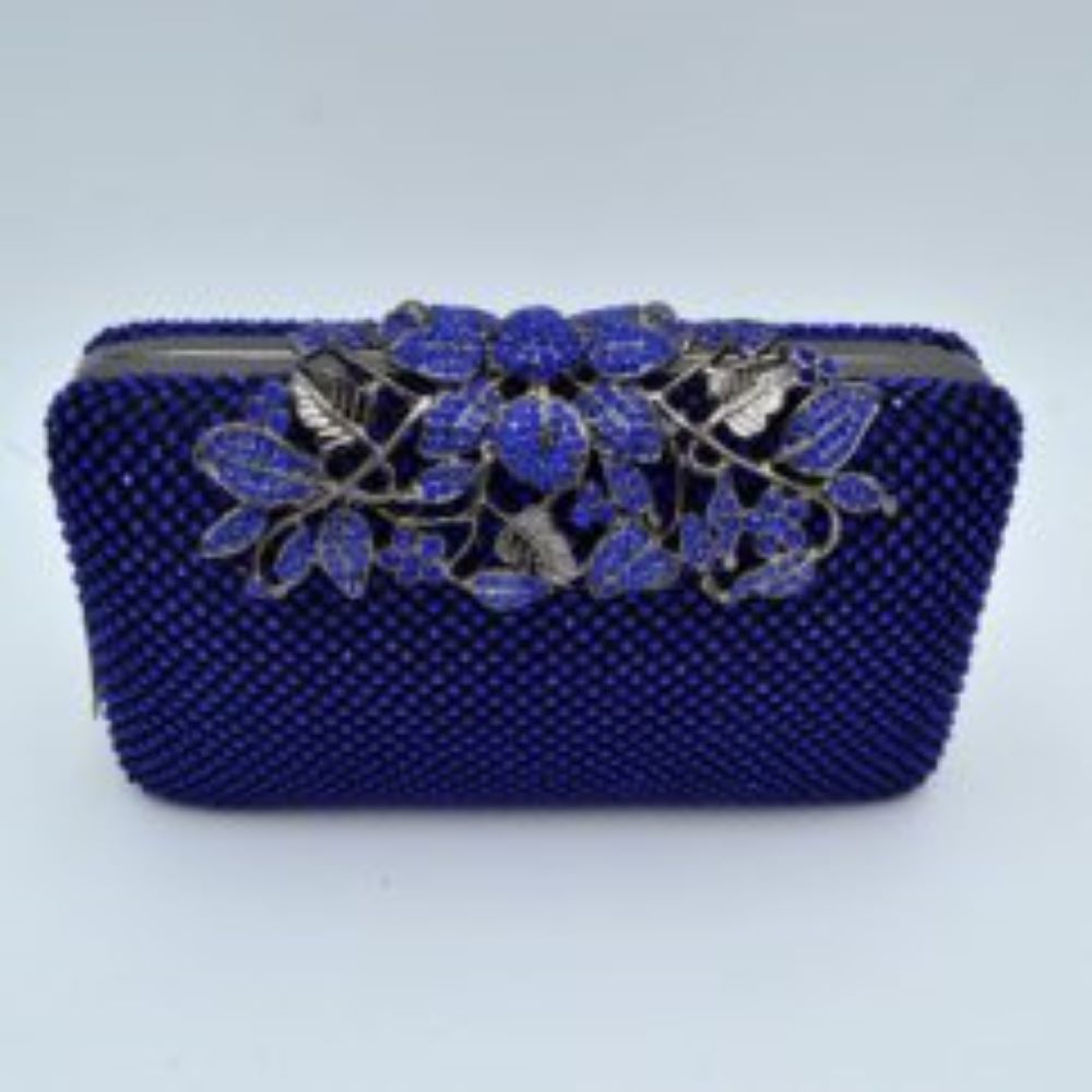 Blue Designed with a rigid rectangular silhouette, this sophisticated box clutch features a meticulously textured exterior composed of small, shimmering circular studs arranged in a uniform pattern. A detailed overlay consisting of metallic leaves and floral accents spans across the top closure, creating an elegant focal point while securing the main storage compartment. A matching link chain strap attaches seamlessly to the top edges