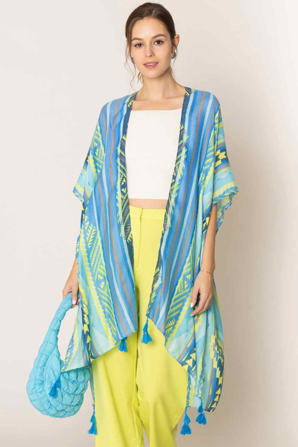 Blue Embrace bohemian elegance with this striking Aztec Pattern Stripe Print Tassel Kimono. Featuring bold geometric designs and traditional stripe patterns, this lightweight piece drapes beautifully over any outfit. Finished with decorative tassels for an authentic touch, it's perfect for layering during warm weather or adding texture to your everyday look. Crafted from 100% polyester for easy care and comfort. Generously sized at 35.4" x 35.4", it offers a relaxed, flowing fit that flatters all body types