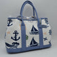 Blue Set sail with this nautical-inspired canvas tote. Featuring a crisp backdrop decorated with a classic print of anchors, sailboats, ship wheels, and ocean waves, this bag is the perfect accessory for coastal getaways or adding maritime flair to your daily ensemble. Framed with structured textured trim, it balances casual resort style with sharp, everyday functionality.