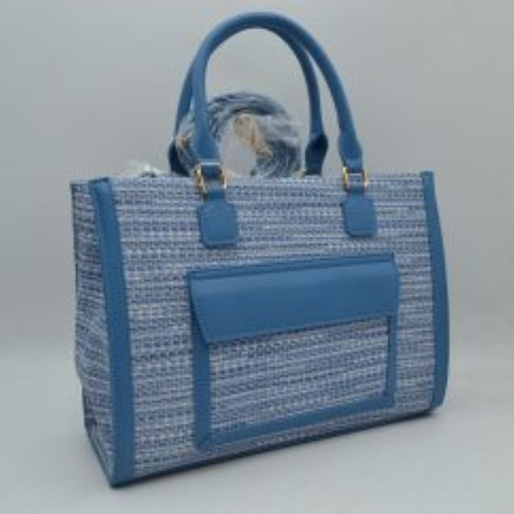 Blue Bring a polished, professional edge to your daily commute with this beautifully structured rectangular tote bag. Showcasing a refined, multi-tonal woven tweed patterned exterior, this handbag is sharply framed by clean, solid-colored vertical trim and a matching protective base that effortlessly retains its crisp silhouette. The front features a prominent, smooth-textured slip pocket with a protective overhanging flap, offering convenient, easy-access storage for smaller items like keys or commuter pas