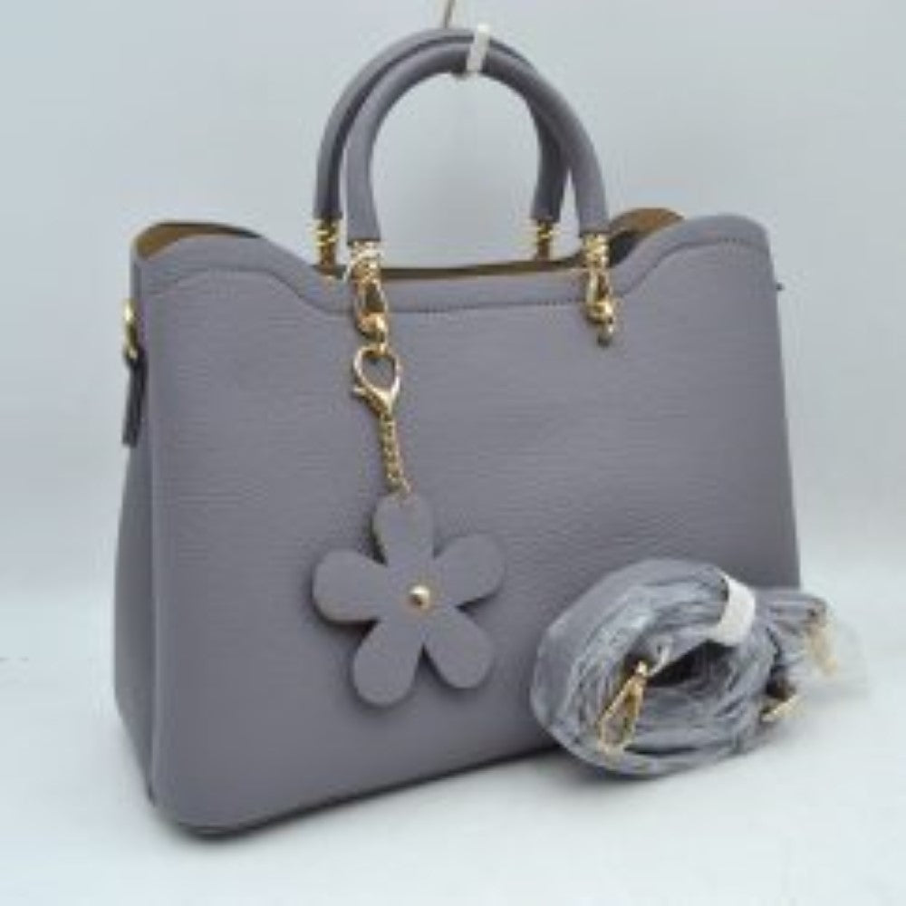 Blue Gray Add a refined touch to your everyday accessories with this stylish satchel bag featuring structured top handles, a spacious interior, and a detachable shoulder strap for versatile carrying options. Designed to balance fashion and functionality, it offers ample room for daily essentials while maintaining a sleek and sophisticated silhouette. Decorative hardware accents and a charming floral pendant enhance its elegant appearance, making it suitable for work, shopping, travel, or casual outings.