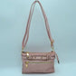 Blush This functional crossbody bag is designed for organized everyday use, featuring a textured exterior equipped with multiple secure storage compartments. The front panel includes a convenient horizontal zippered pocket accented with an oversized metallic zipper pull, situated beneath a decorative horizontal band detailed with metallic studs and loops.