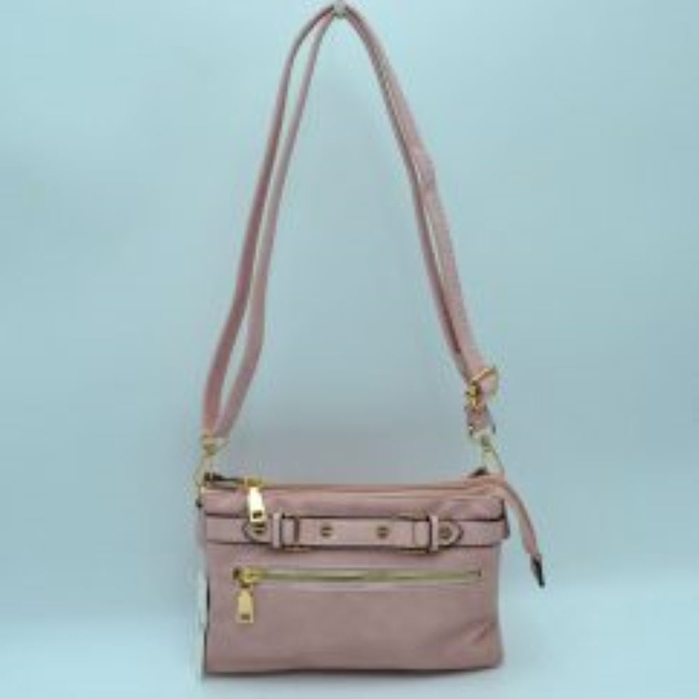 Blush This functional crossbody bag is designed for organized everyday use, featuring a textured exterior equipped with multiple secure storage compartments. The front panel includes a convenient horizontal zippered pocket accented with an oversized metallic zipper pull, situated beneath a decorative horizontal band detailed with metallic studs and loops.