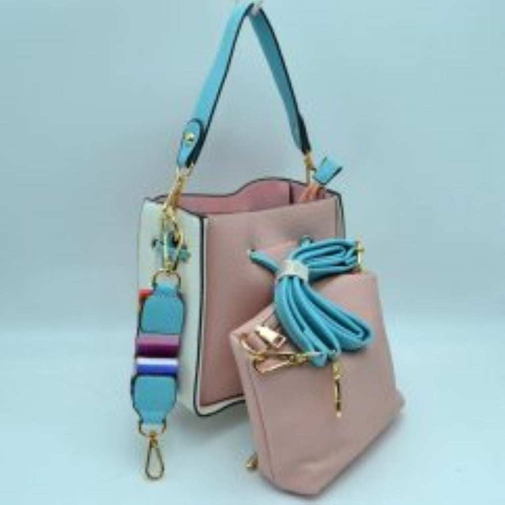 Blush This stylish bucket bag features a distinctive color-blocked design crafted with a pebbled exterior texture, making it a versatile accessory for everyday use. The front panel includes a classic cinch drawstring closure detailed with contrasting trim and polished metallic aglets that open to a secure main storage compartment. Built for flexibility, it is equipped with a structured shoulder handle, an adjustable long shoulder strap