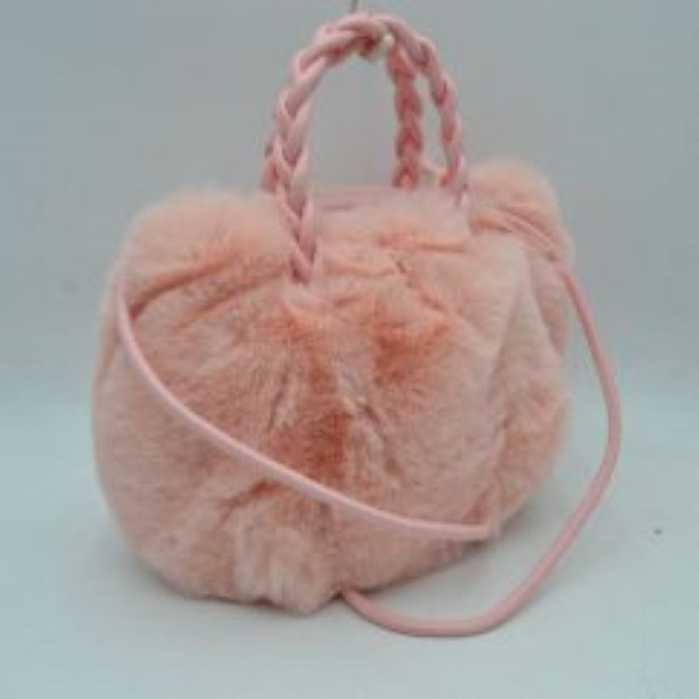 Blush This soft everyday bucket-style handbag features a densely textured, plush exterior that offers a cozy aesthetic for daily use. Designed with a structured yet flexible silhouette, it features dual braided top handles for comfortable hand carrying alongside a slender, long shoulder strap that provides hands-free convenience. The top opening reveals a spacious central storage compartment ideal for organizing essential items