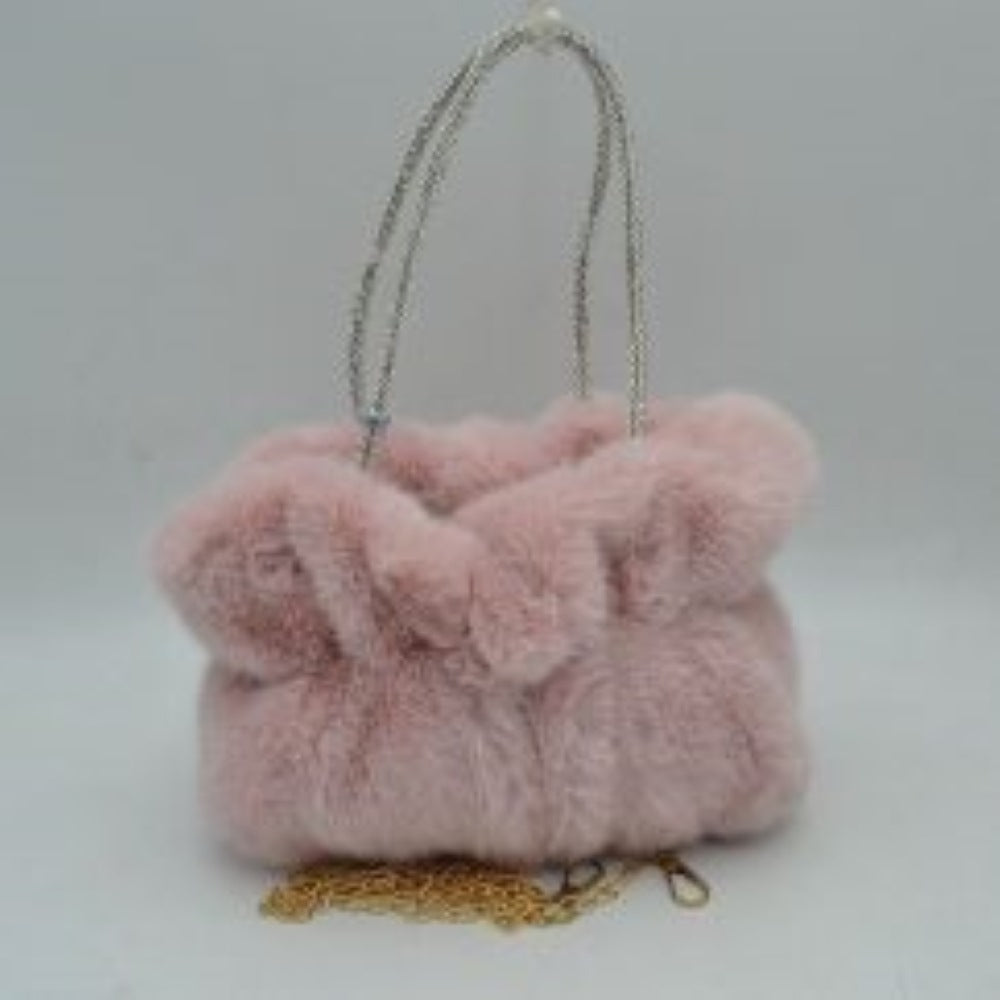 Blush This unique everyday handbag features a soft, dense plush exterior that brings a cozy texture and modern look to your accessory collection. Designed with a slouchy, gathered silhouette, it features a central main storage compartment to keep your daily items within easy reach. The bag stands out with dual top handles covered in shimmering rhinestone details for elegant hand carrying, alongside a detachable metallic chain strap that offers versatile hands-free shoulder wear.