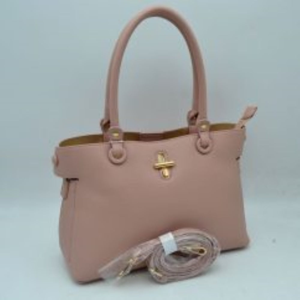 Blush This everyday handbag features a structured silhouette with a distinctively textured exterior surface. Designed for versatile carrying options, it includes dual rounded top handles attached via metallic hardware studs alongside a separate, detachable shoulder strap. The front panel is accented with a prominent metallic turn-lock closure detail.