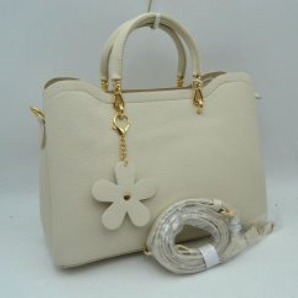 Cream Add a refined touch to your everyday accessories with this stylish satchel bag featuring structured top handles, a spacious interior, and a detachable shoulder strap for versatile carrying options. Designed to balance fashion and functionality, it offers ample room for daily essentials while maintaining a sleek and sophisticated silhouette. Decorative hardware accents and a charming floral pendant enhance its elegant appearance, making it suitable for work, shopping, travel, or casual outings.