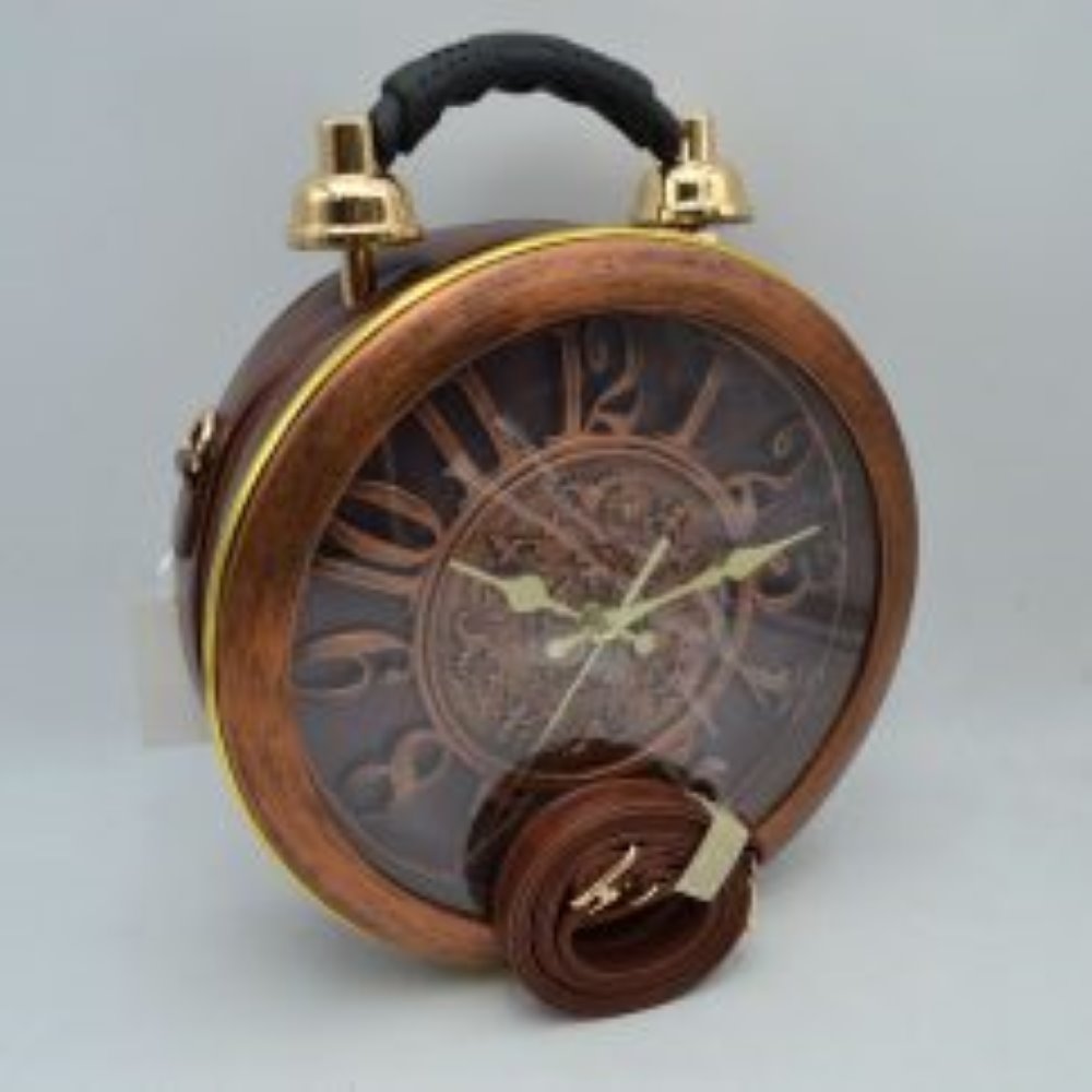 Brown This unique novelty handbag features a structured round silhouette designed to look like a vintage twin-bell alarm clock, making it an exceptional statement piece. The prominent front panel showcases a large clock face detailed with oversized numbers and ornate gold-tone hands, beautifully enclosed within a wood-grain textured circular frame and a clear protective cover. Mimicking a classic alarm clock