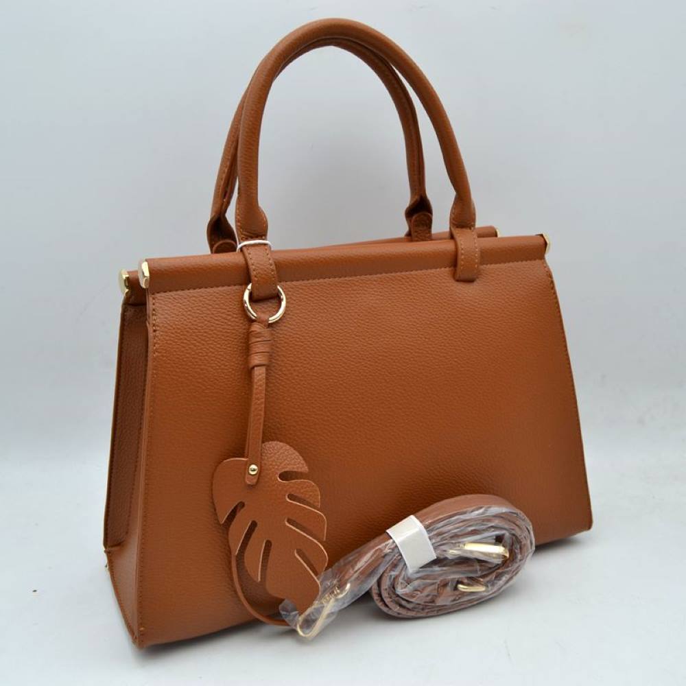 Brown This stylish structured handbag is designed for everyday elegance and practicality. Crafted with a premium textured finish, it features a sleek top-handle design with gold-tone hardware accents for a luxurious touch. The spacious interior provides enough room for daily essentials like phone, wallet, cosmetics, and small accessories, making it perfect for both office and casual use. It also comes with a detachable and adjustable shoulder strap for versatile carrying options.