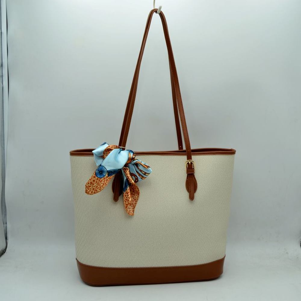 Brown Step out in style with this sophisticated and timeless tote bag. Designed with an understated chevron-style textured weave, this bag seamlessly blends classic elegance with everyday functionality. Perfect for work, travel, or upscale weekend outings, it comes complete with a vibrant, playful silk-style scarf wrapped around the handle for an instant touch of Parisian chic.
