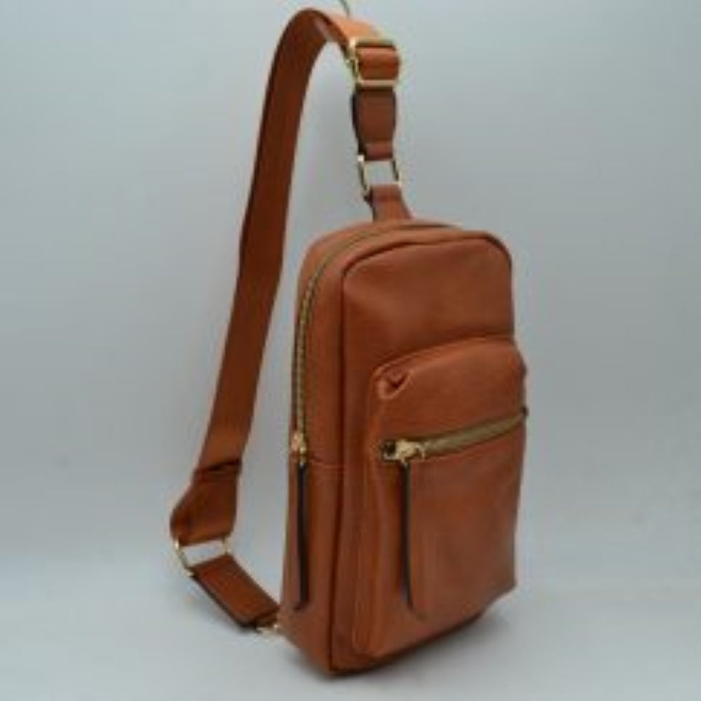 Brown This functional sling bag features a textured, grained finish exterior designed for streamlined everyday use. It offers multiple practical storage compartments, including a curved main section secured by a prominent metallic zipper track and a secondary front pocket with a horizontal zipper and an elongated pull tab. The bag is equipped with a single wide shoulder strap that attaches via a rectangular loop and incorporates an adjustable metallic buckle to easily customize the carrying length.