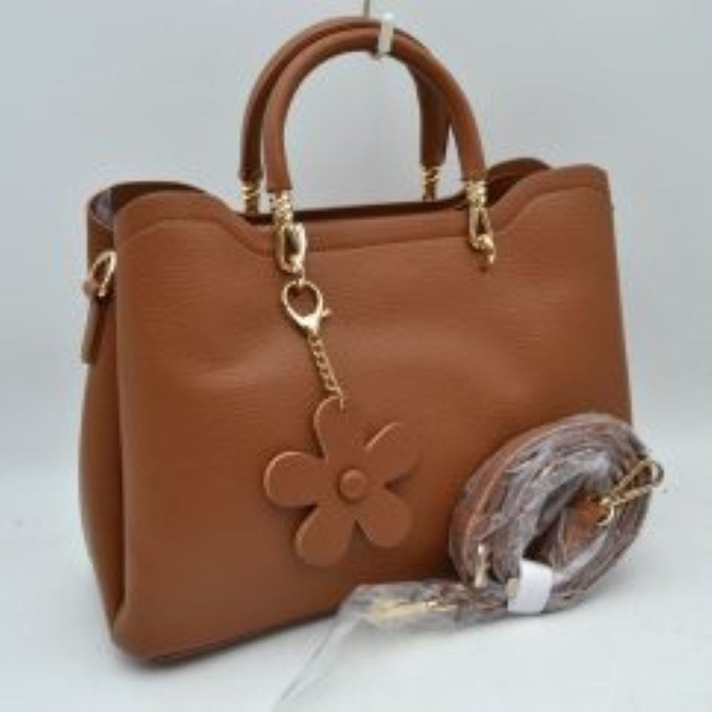 Brown Add a refined touch to your everyday accessories with this stylish satchel bag featuring structured top handles, a spacious interior, and a detachable shoulder strap for versatile carrying options. Designed to balance fashion and functionality, it offers ample room for daily essentials while maintaining a sleek and sophisticated silhouette. Decorative hardware accents and a charming floral pendant enhance its elegant appearance, making it suitable for work, shopping, travel, or casual outings.