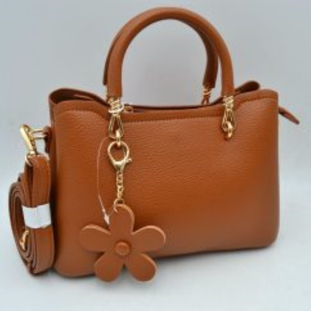 Brown This elegant satchel handbag features a structured silhouette with a pebbled exterior texture, making it a sophisticated option for everyday use. It is equipped with dual rounded top handles anchored by polished metallic loops, alongside a detachable, adjustable shoulder strap connected to the side by a swivel clasp for versatile carrying styles. The main storage compartments include an open side section and a secured top zipper closure to keep essentials organized