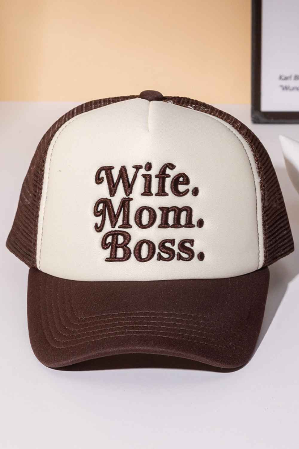 Brown Perfect for the multitasking woman who does it all. This trucker cap features bold "WIFE MOM BOSS" lettering on a structured foam front with breathable mesh back paneling. The snapback closure ensures a comfortable, adjustable fit for any head size. Made from 100% polyester for durability and easy care. Whether you're heading to work, running errands, or just making a statement, this cap celebrates your hustle with style and attitude.