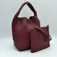 Burgunday This stylish everyday hobo bag features an all-over classic basket weave design and a slouchy silhouette. It is crafted with a seamless, integrated wide top handle that transitions directly into the main storage compartment for comfortable hand or shoulder carrying.