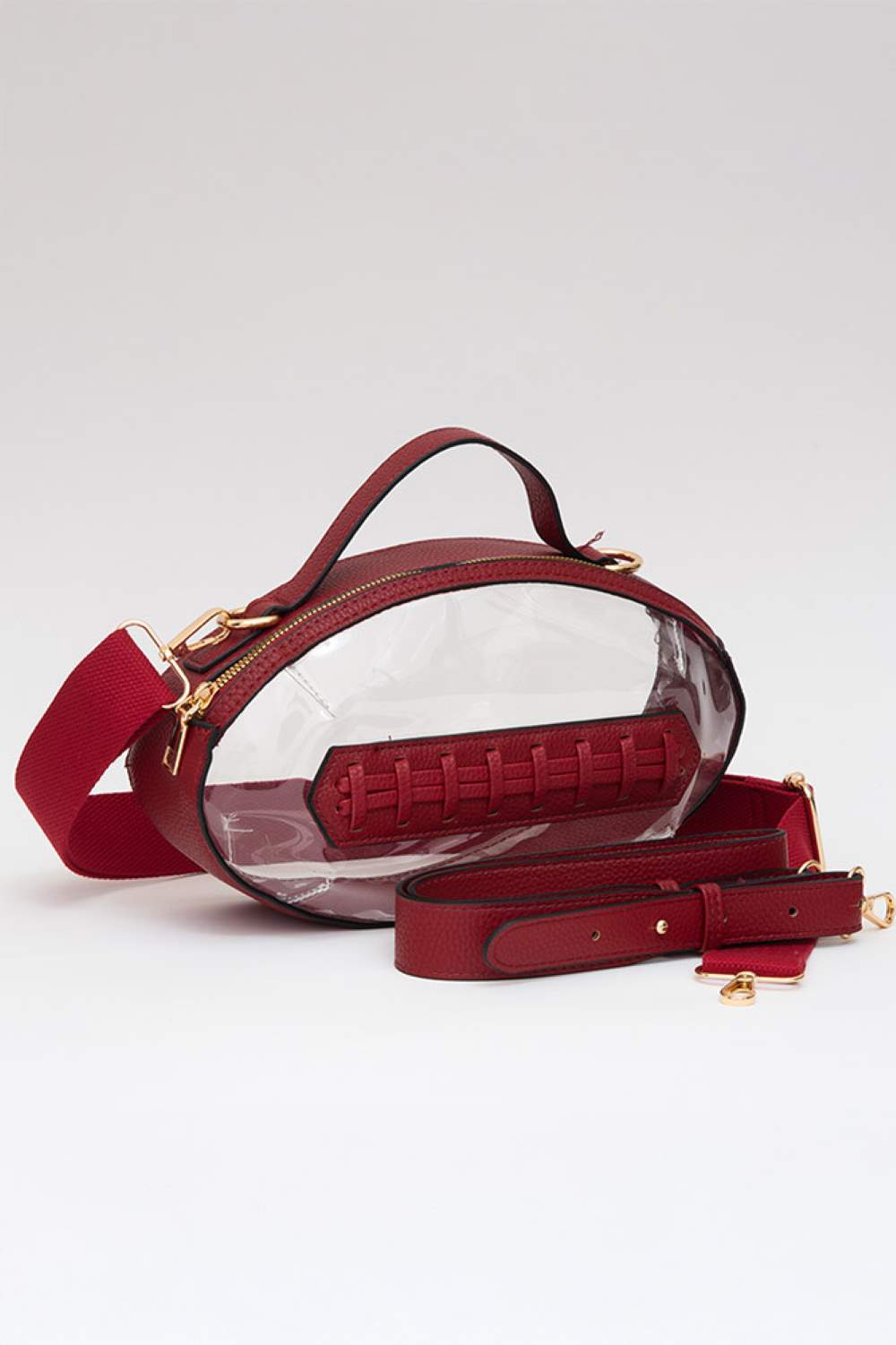 Burgundy Carry your essentials in style with this unique football-shaped transparent crossbody bag. Perfect for stadium events, concerts, and outdoor gatherings, the clear PVC design lets you see everything inside while meeting venue security requirements. Measuring 11" x 6" x 4", it offers practical storage without bulk. The adjustable crossbody strap keeps your hands free, making it ideal for busy days out. Durable 100% PVC construction ensures long-lasting wear through countless adventures.