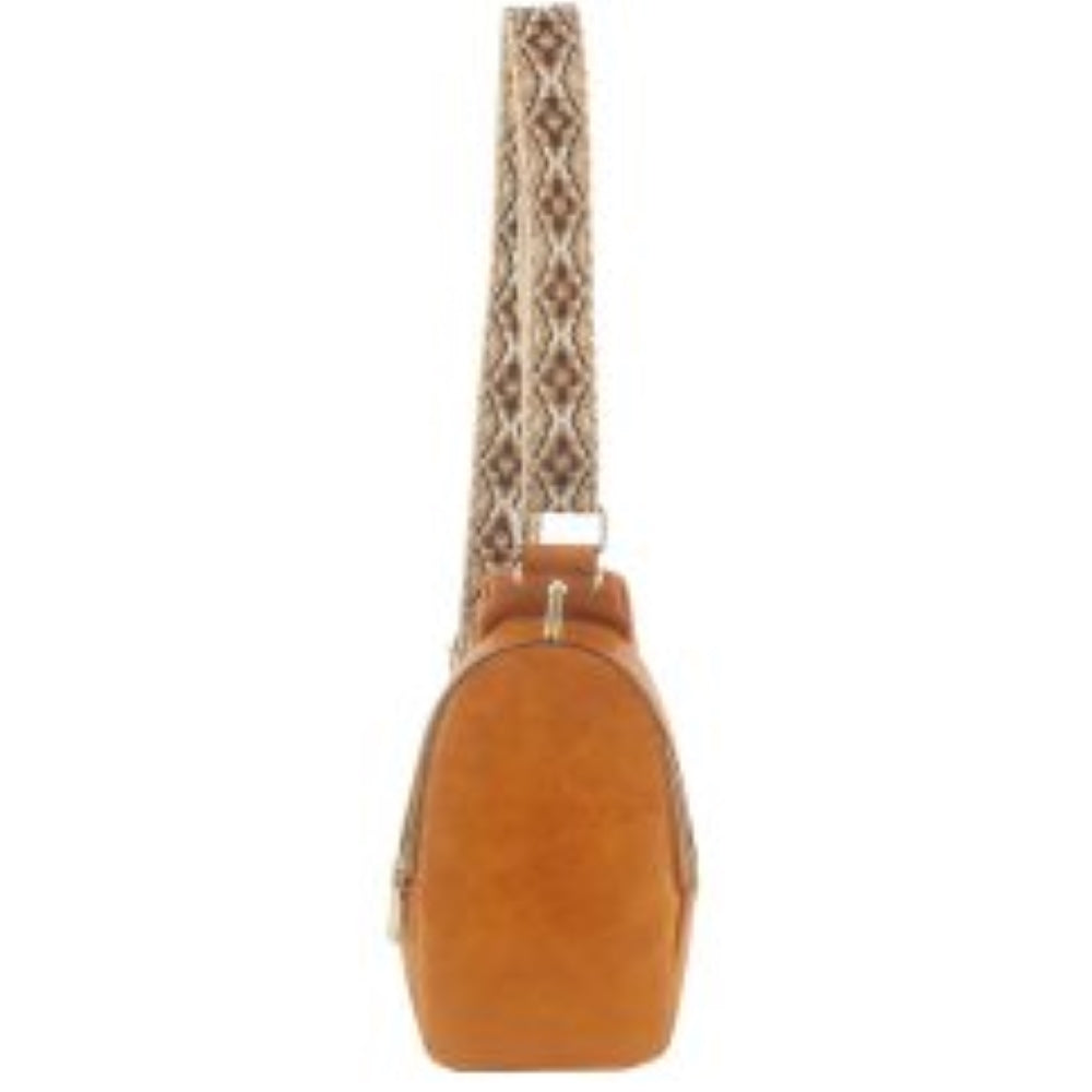 Camel This compact sling backpack features a smooth textured finish and a contoured, teardrop-shaped silhouette designed for casual everyday use. It includes a primary storage compartment that secures with a prominent gold-tone zipper and a flat pull tab for easy access to essentials. A distinctive, wide shoulder strap decorated with an intricate geometric pattern connects via gold-tone metal clips to various anchor loops, allowing for adjustable and versatile cross-body or over-the-shoulder wear.