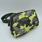 Camo green This minimalist bag features a smooth, clean design ideal for versatile everyday use. The main storage compartment is secured by a curved top zipper with dual pulls for easy access to essentials. A wide, adjustable strap extends from the sides, complete with a matching slider to easily customize the fit for comfortable carrying.