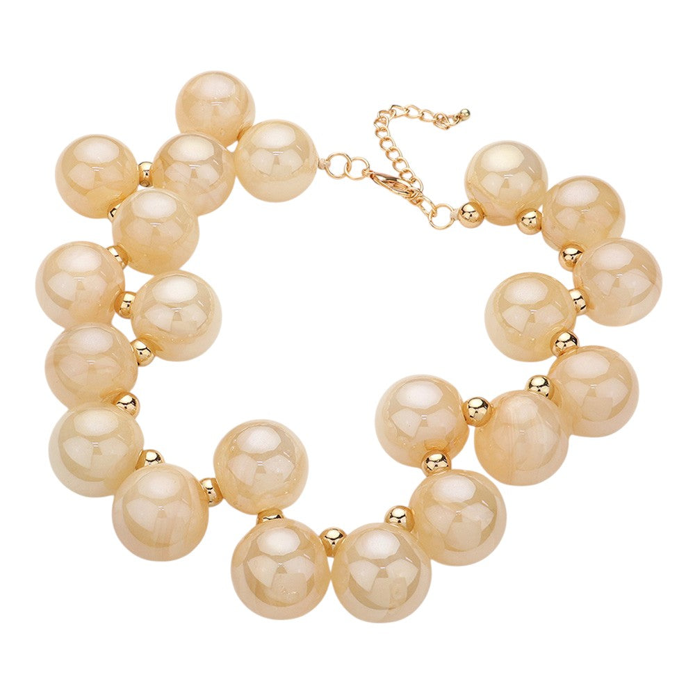 Champagne chunky iridescent ball beaded necklace elevates any outfit with its unique and eye-catching design. The perfectly placed beads create a glamorous and statement-making accessory. Crafted with quality materials, this necklace is a must-have for any fashion enthusiast. 