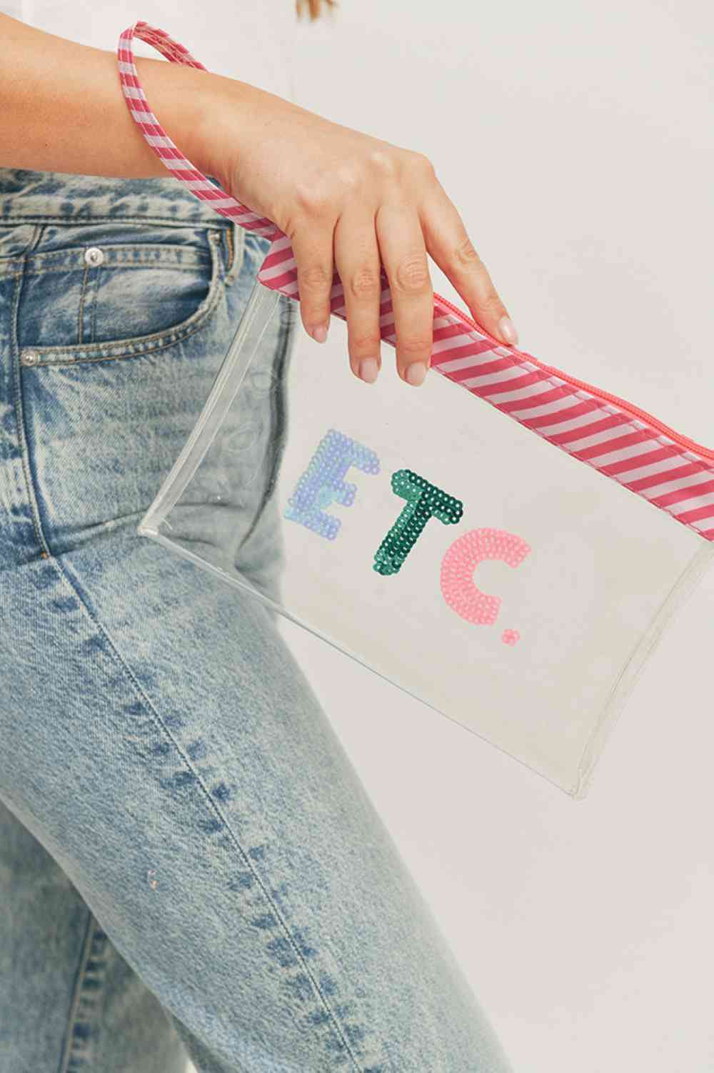 Clear Carry your essentials in style with this ETC Sequin Letter Clear Pouch. Crafted from durable 100% PVC, this transparent design lets you see everything inside at a glance. Measuring 9.5" x 7", it's the perfect size for cosmetics, small accessories, or travel necessities. The convenient wrist strap keeps your hands free while keeping your items secure. A fun and functional addition to any bag or outfit.
