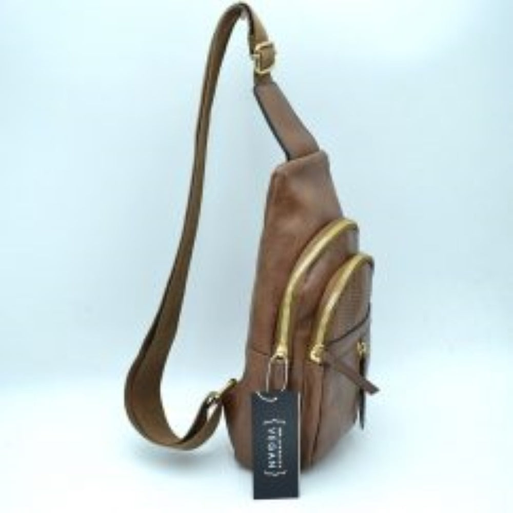 Coffee This functional sling bag features a textured, subtly grained exterior with an asymmetric silhouette ideal for active everyday use. It provides multiple organized storage compartments, including a spacious curved main section, an intermediate arched front pocket with a decorative perforated design, and a lower pouch featuring a vertical zipper closure and an elongated pull tab. The design is completed by a single wide
