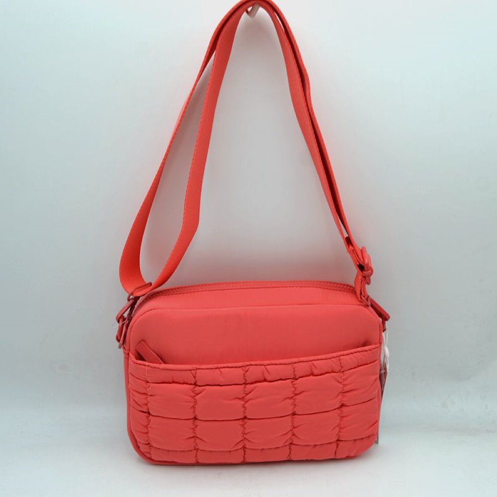 Coral This practical crossbody bag is designed for effortless everyday use, featuring a distinct quilted pattern across the lower front section. It offers multiple storage compartments, including a secure main zippered closure and an easily accessible front slip pocket to organize your daily essentials. A wide, adjustable shoulder strap ensures comfortable, customizable carrying, making it a perfect accessory for hands-free convenience while on the go.