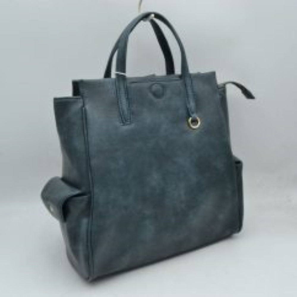 Dark This everyday tote bag features structured dual top handles for hand or forearm carrying, paired with a secure top zipper closure that extends slightly beyond the edge. The front panel is detailed with a covered central button accent and a small metallic ring attached near the base of one handle. Designed for convenient organization, the exterior includes functional side pockets with buttoned flaps, while the main compartment offers ample storage space for daily essentials.